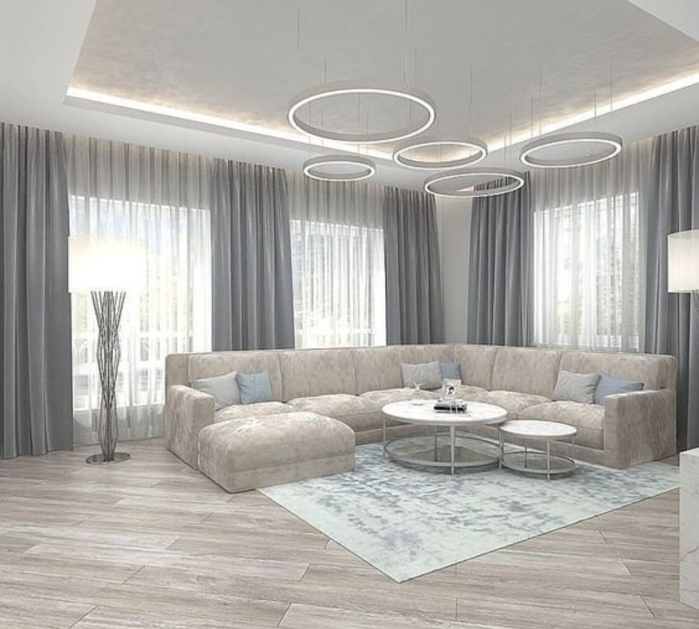 Soggiorno luminoso con divano angolare e lampadario ad anelli
