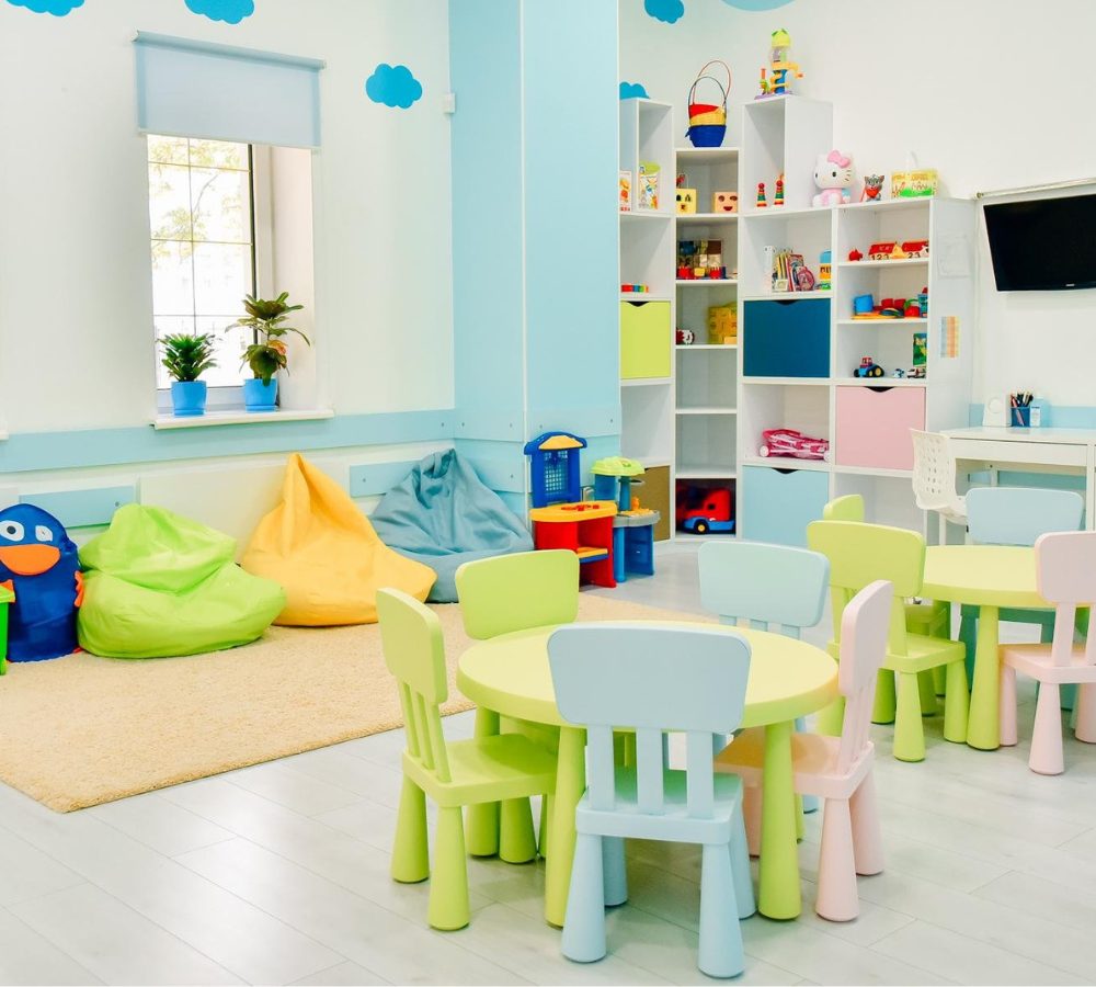 Kindergarten-Spielraum mit Kindertischen und -stühlen