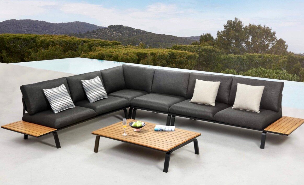 Divano angolare da giardino e tavolino su una terrazza con vista sulle colline