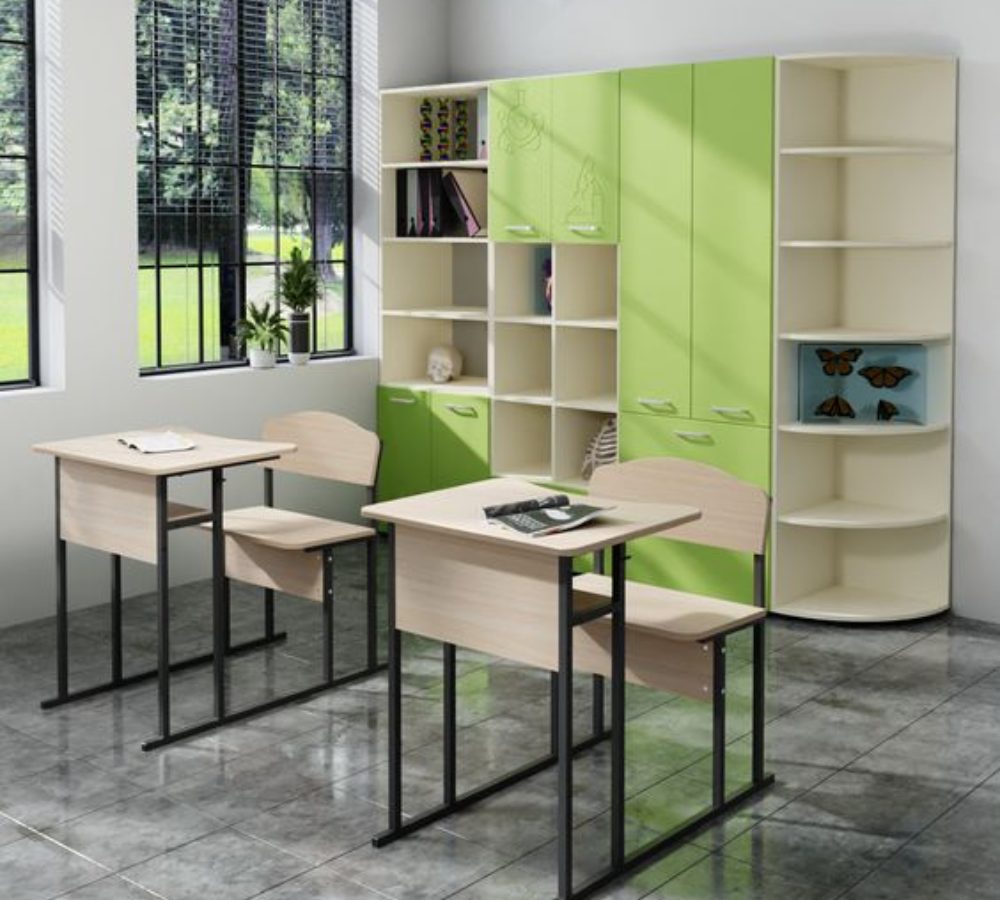 Klassenraum mit Tischen und grünen Schränken