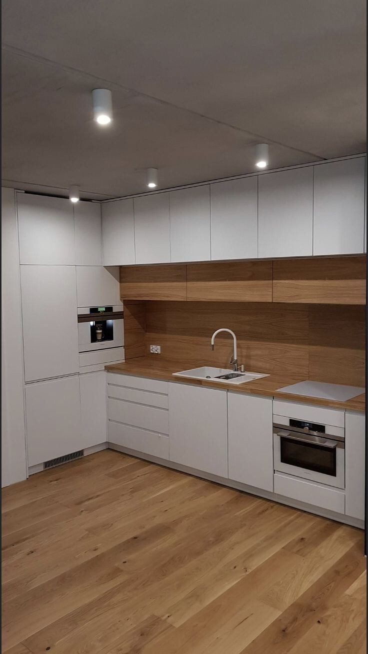 Schmale Küche mit Holzrückwand und Einbaugeräten