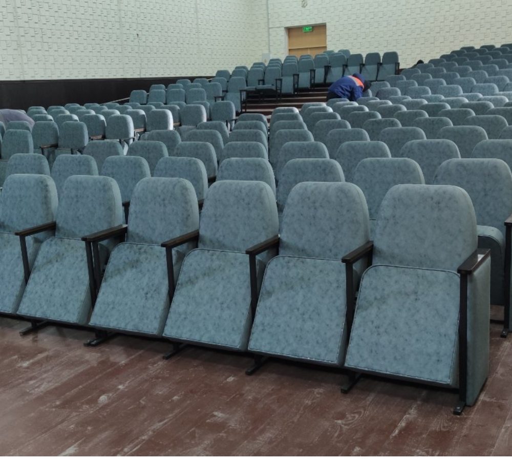 Poltrone grigie installate in file in un'aula magna