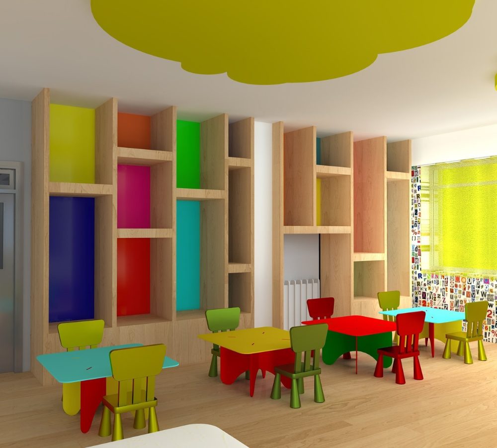 Bunte Regale und Kindertische im Gruppenraum