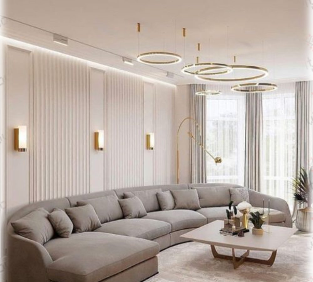 Soggiorno con lungo divano grigio e lampadario ad anelli