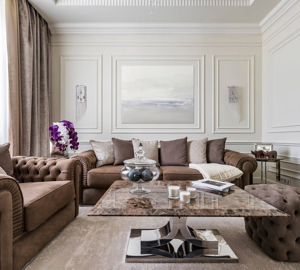 Soggiorno con divano Chesterfield marrone e tavolino in marmo