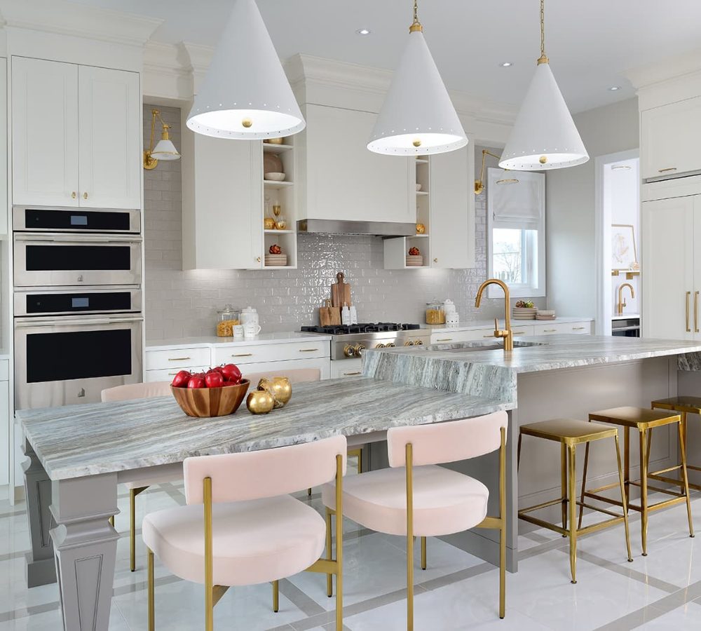 White kitchen with a marble island and pink stools