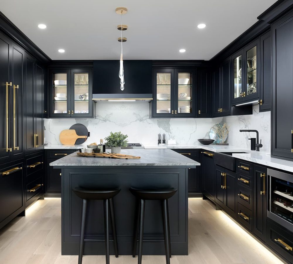 Black kitchen with an island and plinth lighting