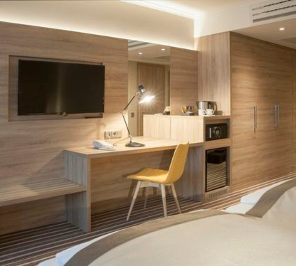 Hotelzimmer mit Schreibtisch, TV-Paneel und Minibar