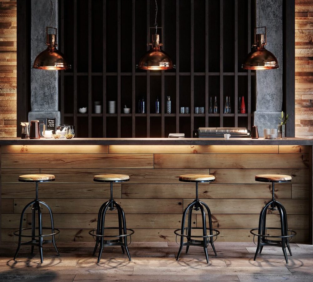 Bancone bar con lampade in rame e sgabelli